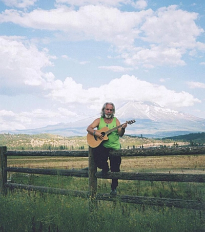 Van of Urantia posing with guitar in front of Mt. Shasta before concert